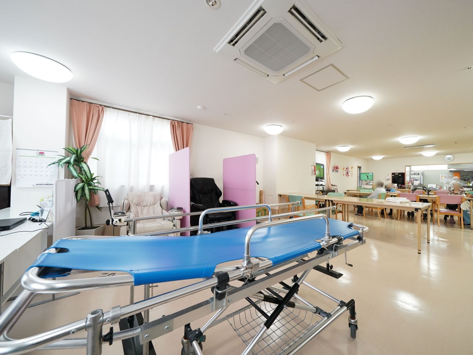 食堂にはテーブルと椅子が並べられている。少し離れた場所には２台のマッサージチェアやベッドが置かれている。