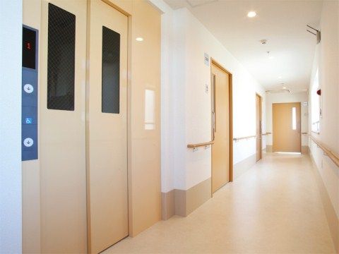 白とベージュを基調としたエレベーターホールは、落ち着いた雰囲気である。自立の方でも安全に移動が行えるように手すりを完備している。