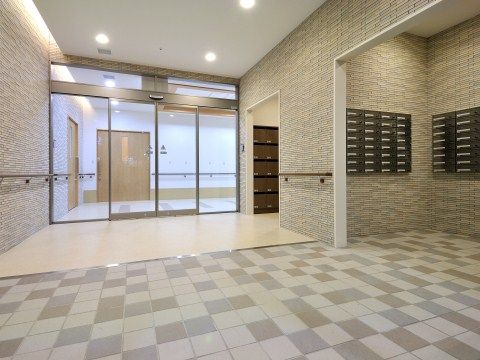 エントランスの壁には手すりが付いている。中へ入ると、集合ポストの一角があり、少し奥まっているのでプライバシーを守って郵便物をチェックできる。