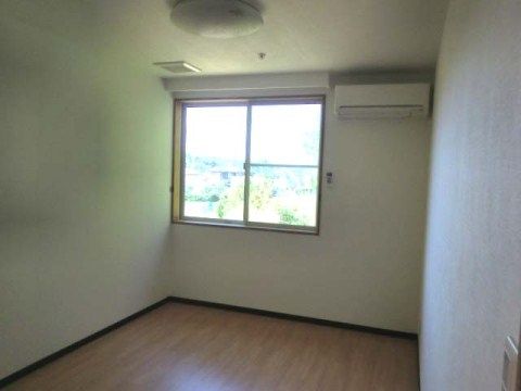 腰高の窓の右側の壁上部にエアコンが設置されている居室