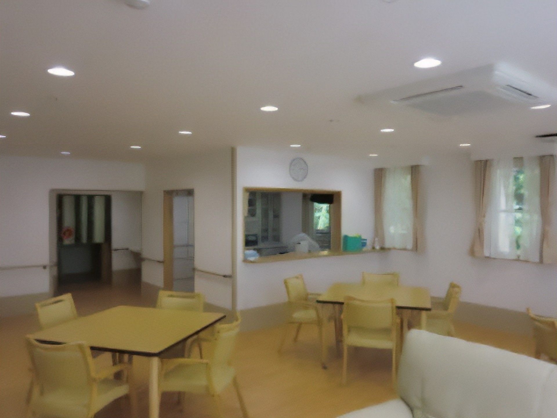 正方形の天板がついたテーブルの周りに椅子が４脚ずつ置かれている食堂