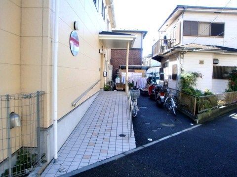 敷地内に道路から玄関につながる通路を設けている。足腰に自信のない方も安全に入館いただけるように手すりを完備している。