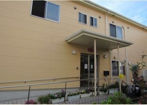 クリーム色の２階建ての外観は、鮮やかな印象である。近くには学校もあり、子供をはじめ地域の人達との交流も身近に楽しめる環境である。