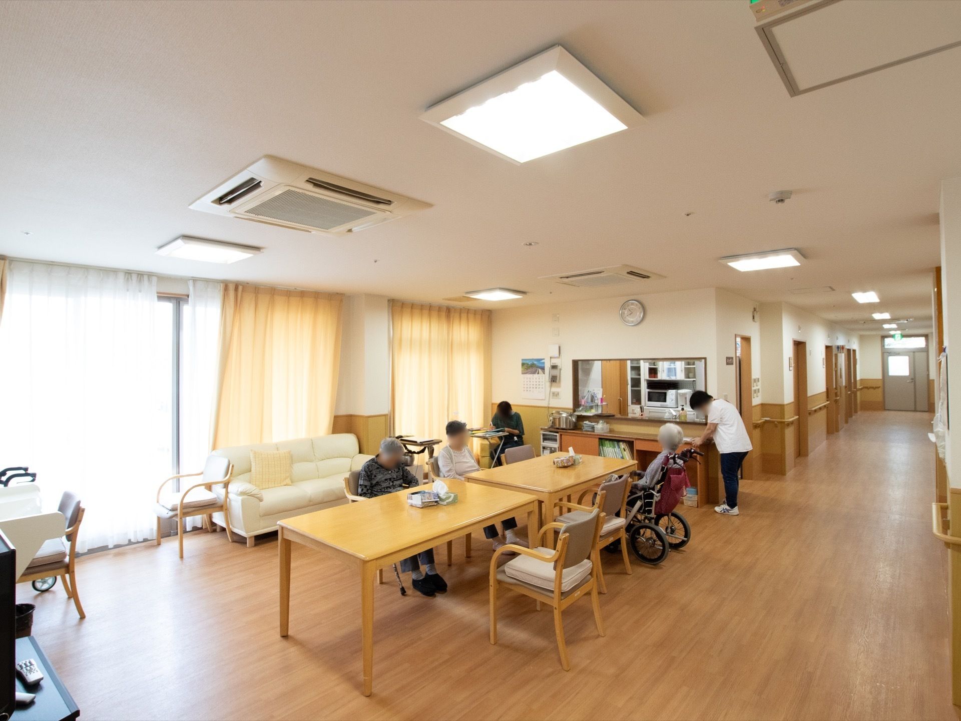 リビングは広く、天井も高い。日当たりが良いので明るい雰囲気である。入居者様は椅子に座ってのんびり過ごすことができる。