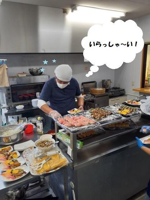 調理中のスタッフと食事