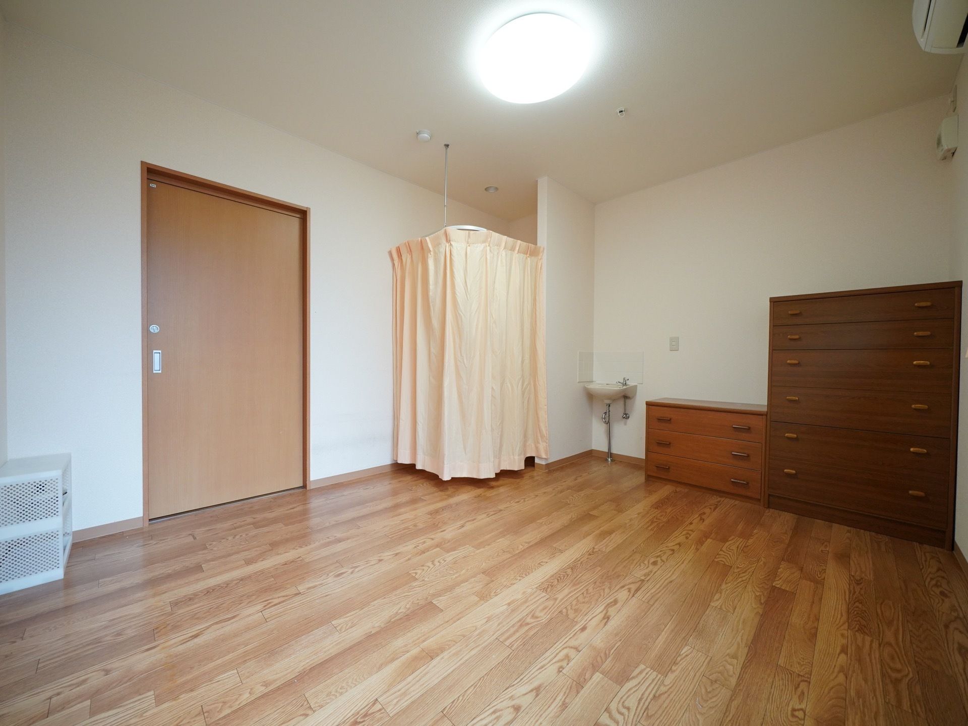 床は木材を使用しており、ぬくもり感がただよう居室である。大小の収納家具、洗面台などが完備されている。