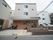 グレーと茶系に施された、3階建ての施設である。建物の前には黒色の自転車が停められている。車も停車できる広さがある。