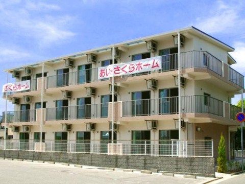 駐車場の隣にある、横に7室、高さ３階建てのベランダ付きの施設