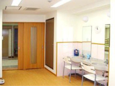 入り口は段差のないスライドドアになっている。壁に縦長の２枚の鏡が設置され、２か所の洗面台の前にそれぞれ椅子が置いてある。