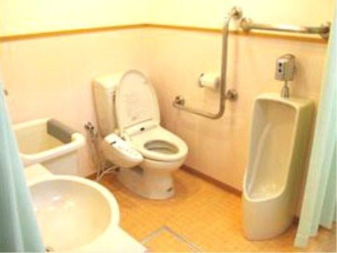 タンク付きの洋式トイレと男子用便器が設置されている。丸いボウルの手洗い場と大きな四角い流しが取り付けられている。
