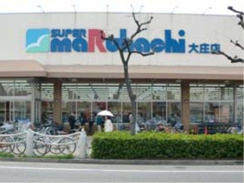 大きな通りに面するスーパーマーケットである。多くの買い物客の姿が見える。入り口は2重扉になっている。