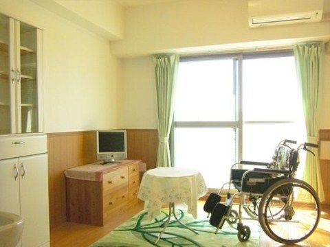 食器棚、引き出し、テレビ、小さなテーブル、車椅子のある個室