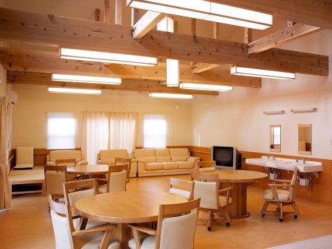天井に木製の梁が組まれた、デザイン性のある部屋である。右奥にテレビが設置されており、その隣に洗面台がある。