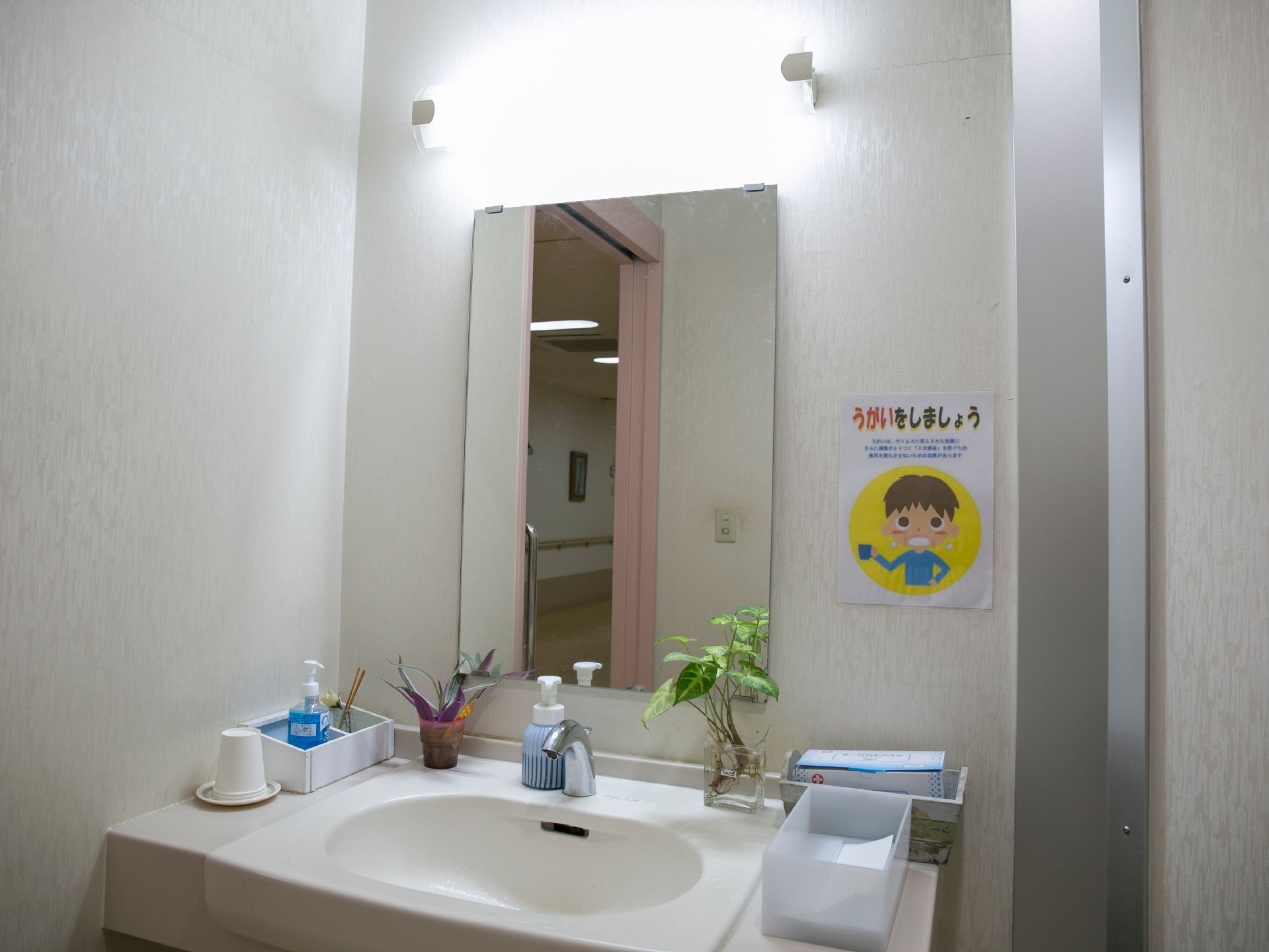 洗面台には手洗い洗剤やペーパータオルが用意されている。またいつでもうがいができるように、紙コップが置かれている。