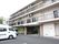 ベランダ付き３階の建物がマンションのような見た目の施設となっている。横にはらせん階段がある。外には駐車場が完備されている。