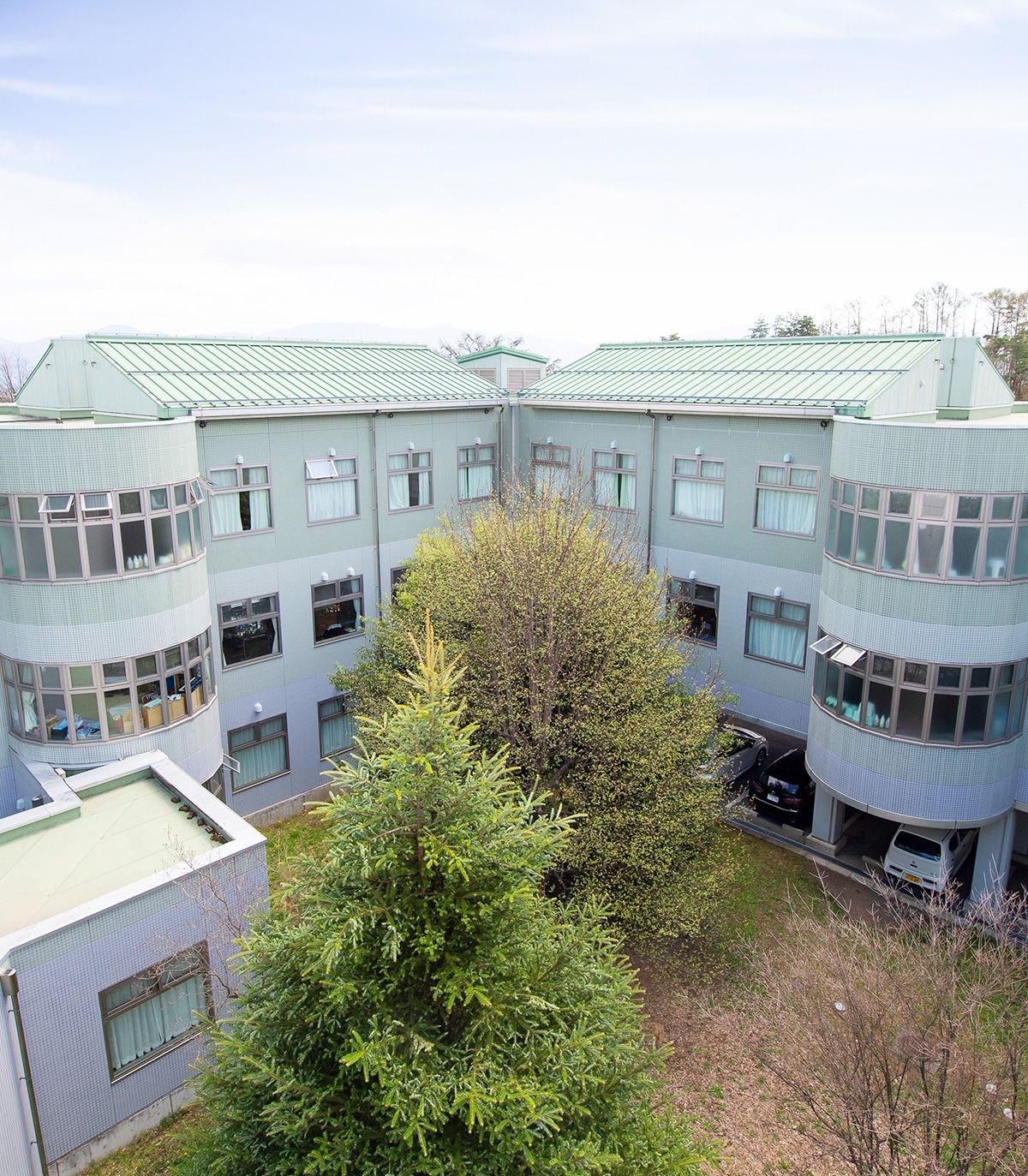 緑に囲まれた建物外観