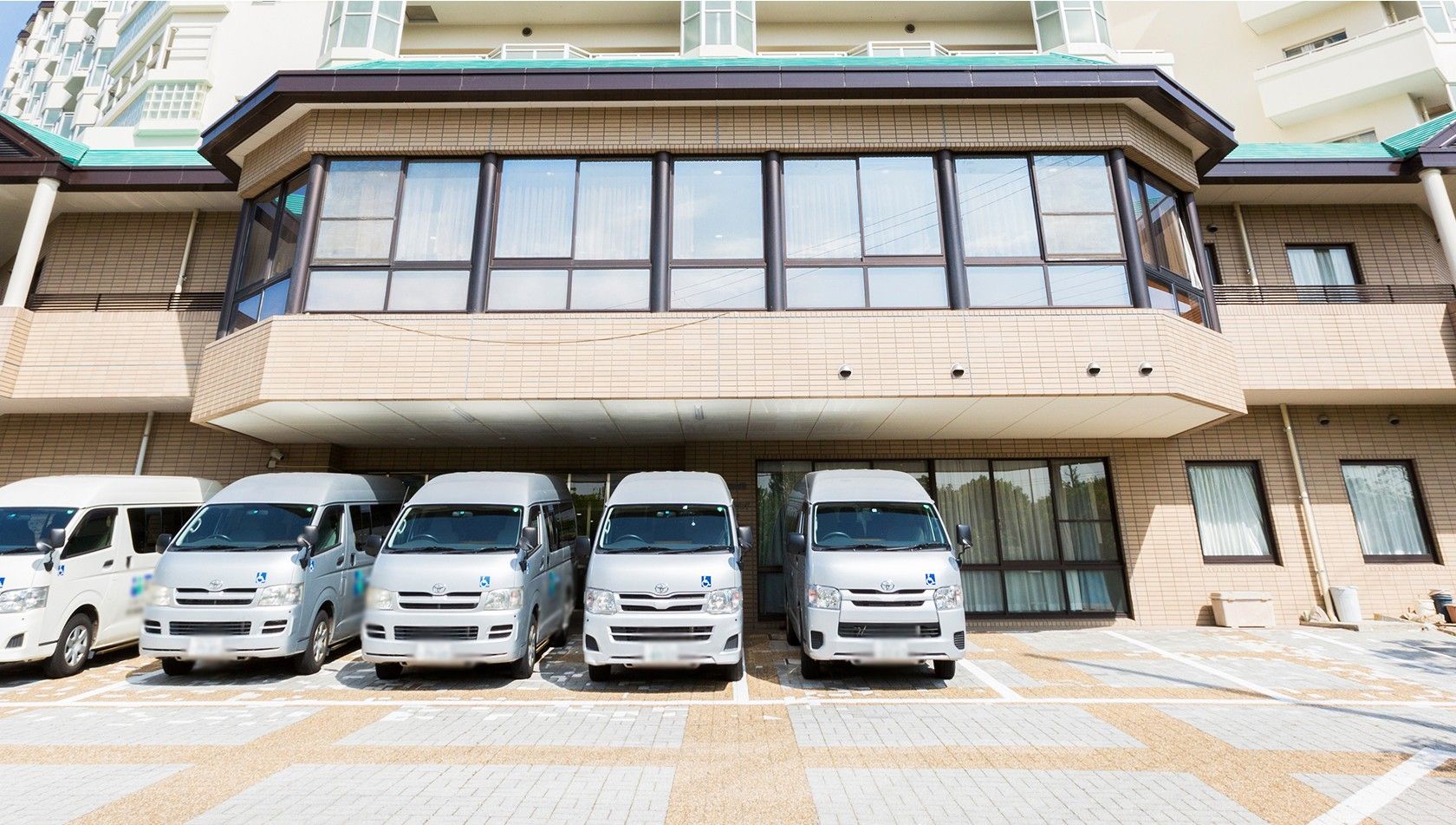 送迎車が並ぶ建物前