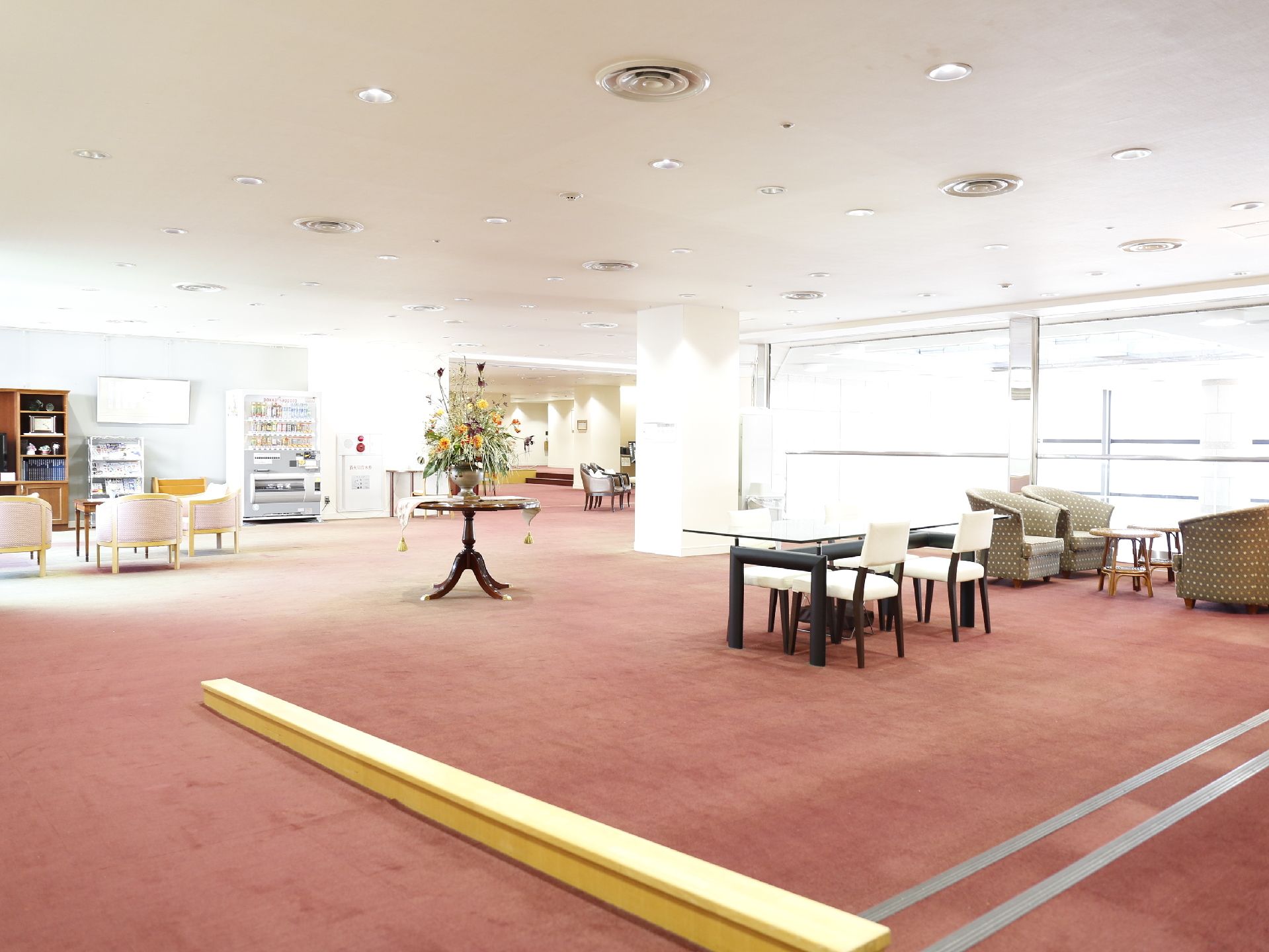 多くの入居者が利用するリビングは非常に広い面積を有し、その全体に赤い絨毯が敷かれている。段差のないバリアフリー構造。
