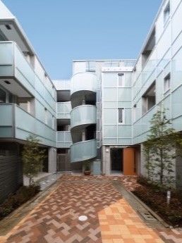 茶系のタイルで舗装された通路を囲むように建つ３階建ての施設