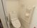 居室のトイレはウォシュレット付きの便座を設置している。また上部には棚があり、壁にはタオル掛けも用意されている。