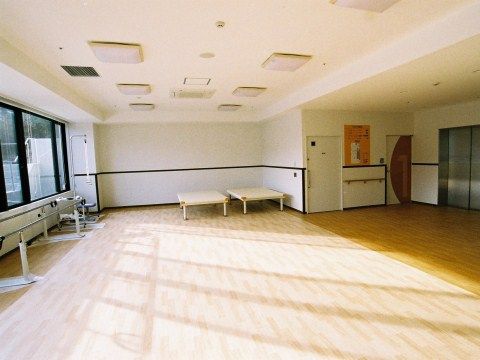 リハビリ用の器具が並ぶ、ジムを思わせるような広いフローリングの部屋
