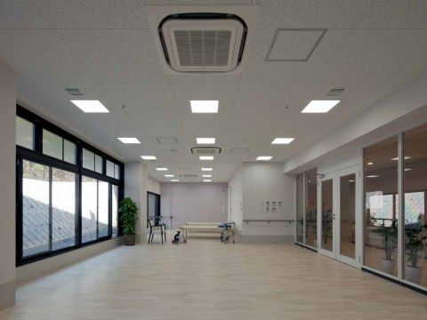 片面が窓、片面が廊下に面するガラスの壁になっている、広いリハビリルーム