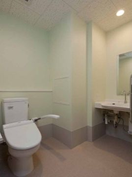 トイレと洗面台は同じ空間にある。トイレには可動式の手すりが付いているので、安心して利用していただける。