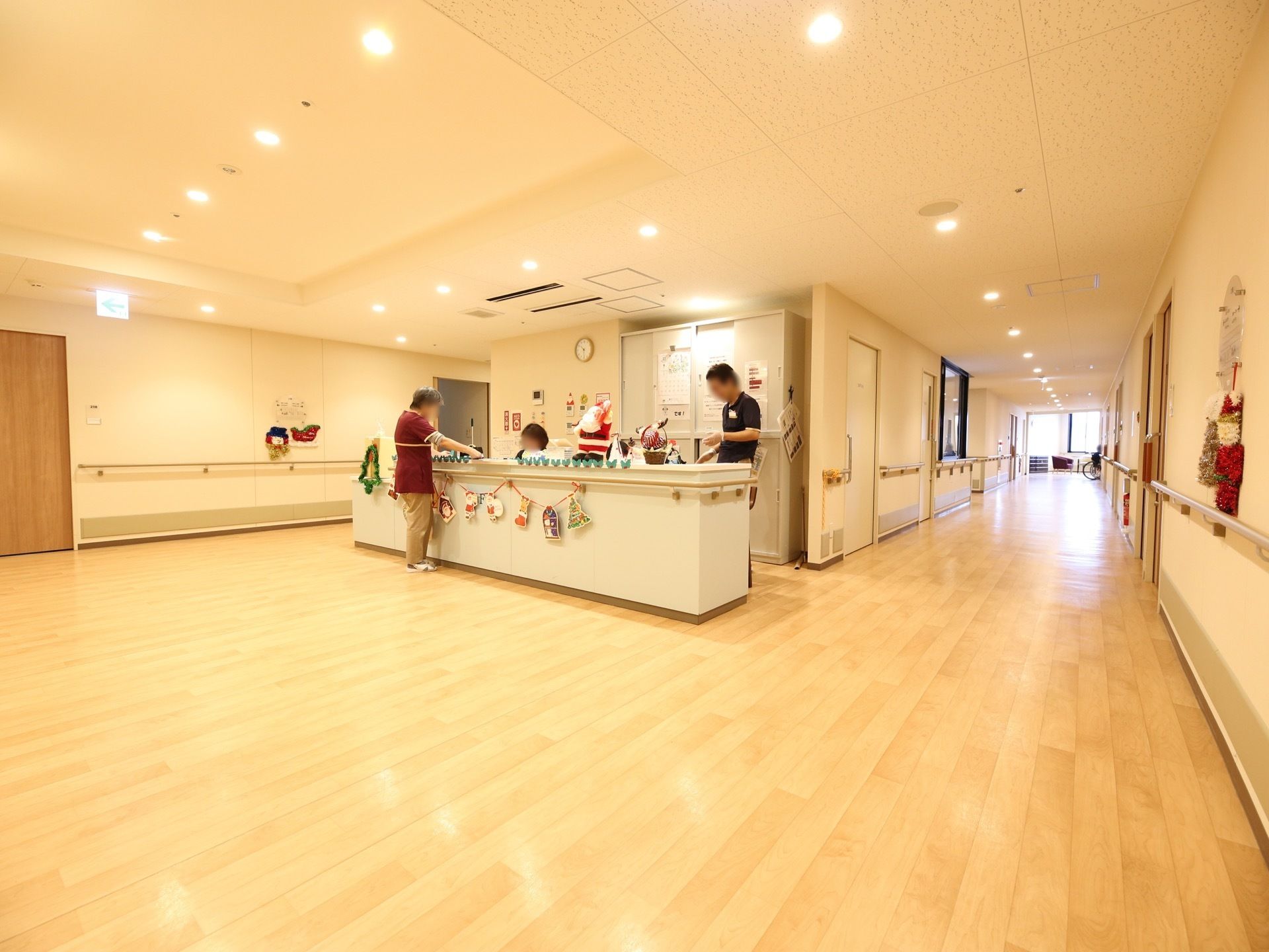 広い通路にスタッフルームがある。居室から近く、入居者様の様子や状態を把握しやすい。手すり付きのカウンターがあり、入居者様も気軽に立ち寄れる。