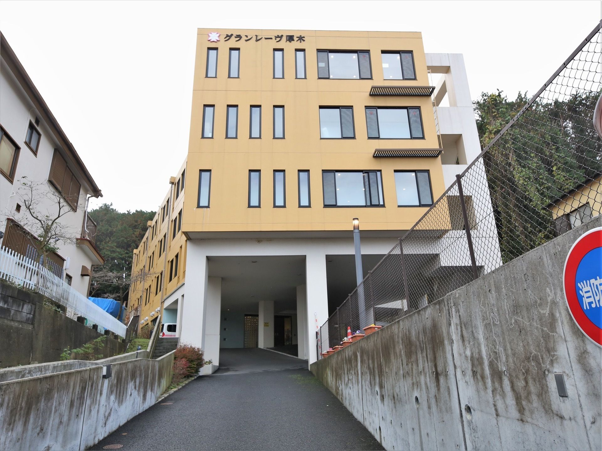 白と黄土色の４階建ての建物である。多くの窓が設置されている。玄関までは坂道となっていて、周囲は自然に囲まれている。