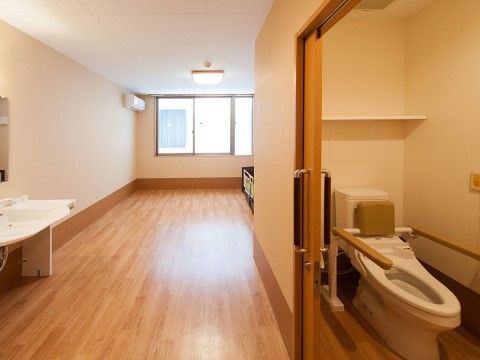 居室の入口付近に設置されている、手すり付き便座のあるトイレの個室