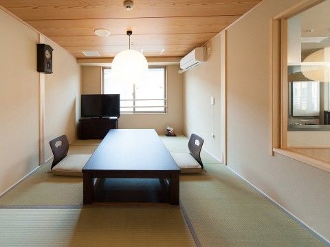 和風の照明や時計が設置され、テレビと座卓、座椅子が2つある和室