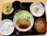 黒いお盆の上に一人分の食事がきれいに並べられている。主食、主菜、副菜、汁物がそろい、栄養バランスが良い。