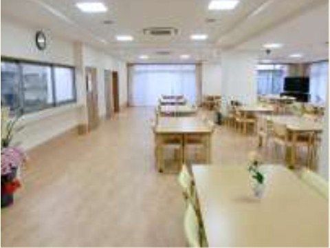 4人掛けのテーブルセットがいくつも並ぶ、窓の多い食堂