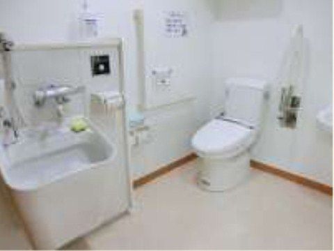 オストメイト対応のトイレとなっている。バリアフリーの広い空間には手すりが取りつけられている。白を基調としており清潔感がある。