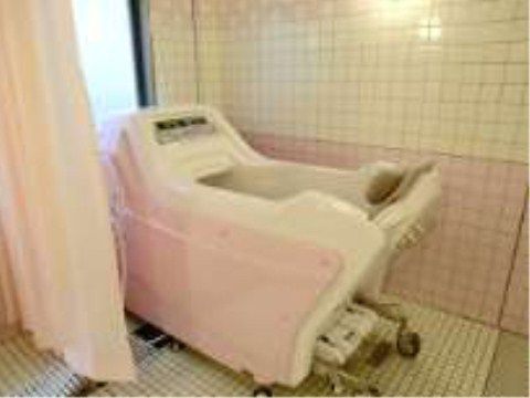機械浴ができるタイル張りの浴室。シャワーカーテンが取りつけてあり、プライバシーも保護される。大きな窓があって明るい。