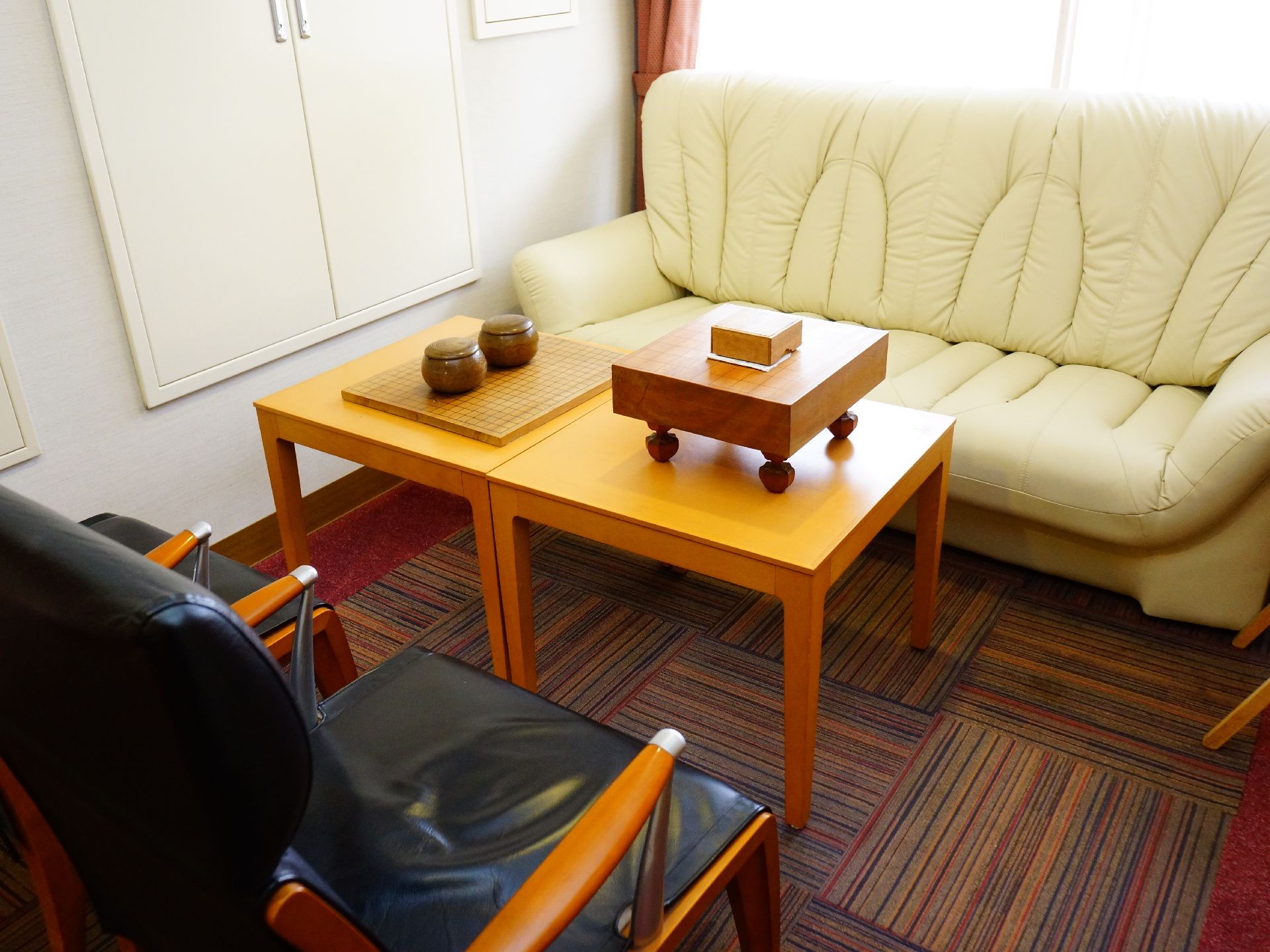 白色のゆったりとしたソファと、黒い椅子、テーブルが置かれている。テーブルには将棋と囲碁のセットが置かれている。