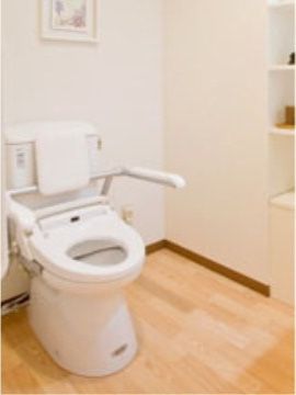 居室のトイレは車椅子のまま入れるように広い造りになっている。便座部分にも手すりが付いていて使いやすい。
