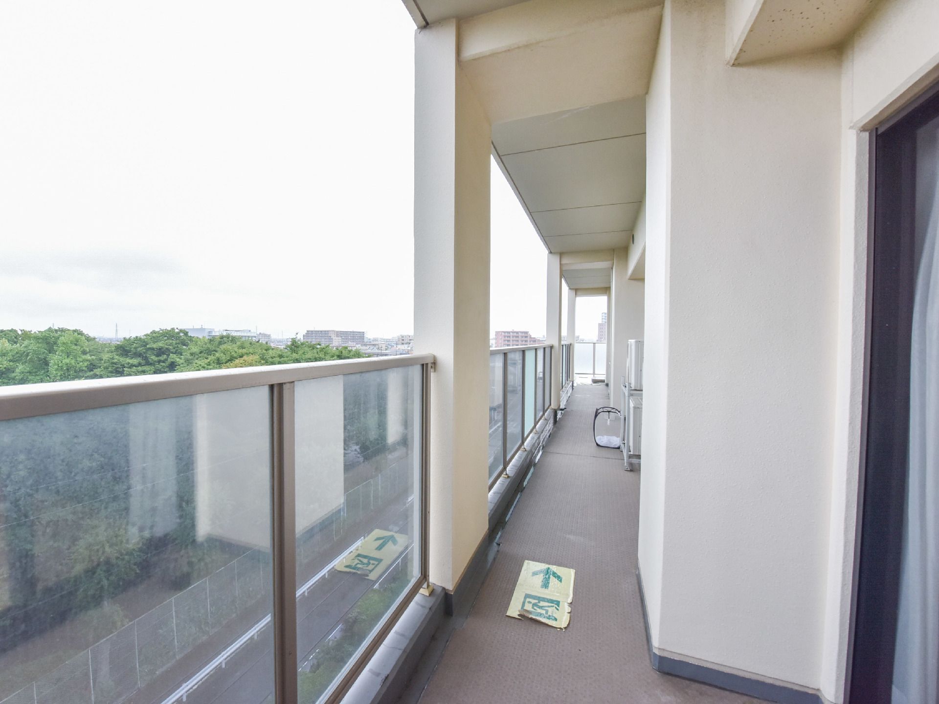 個室にあるベランダの柵はガラスになっている。また、隣室と繋がっていて避難経路が分かりやすいように地面に表示されている。