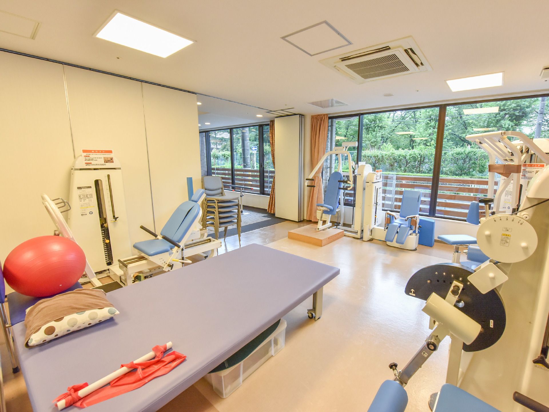 大きな窓がある部屋はリハビリルームとなっている。部屋には種類の違うリハビリ器具が置かれている。中にはバランスボールもある。