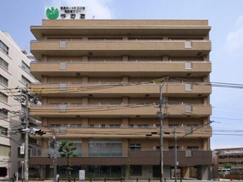 電線や信号機の向こうに建つ、7階建てで茶色の頑丈そうな建物