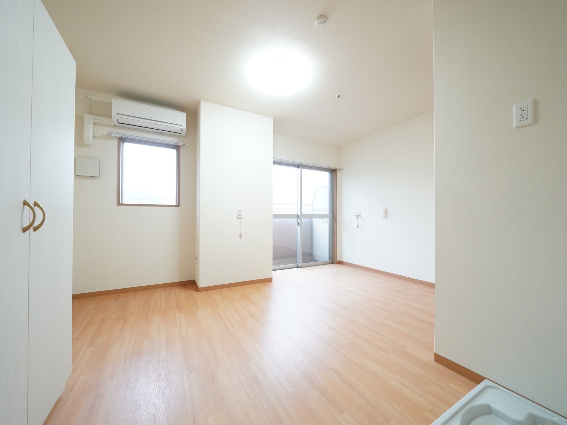 ゆったりとした造りの洋室である。大きな窓とベランダがあり、明るく開放感がある。エアコンが完備されている。