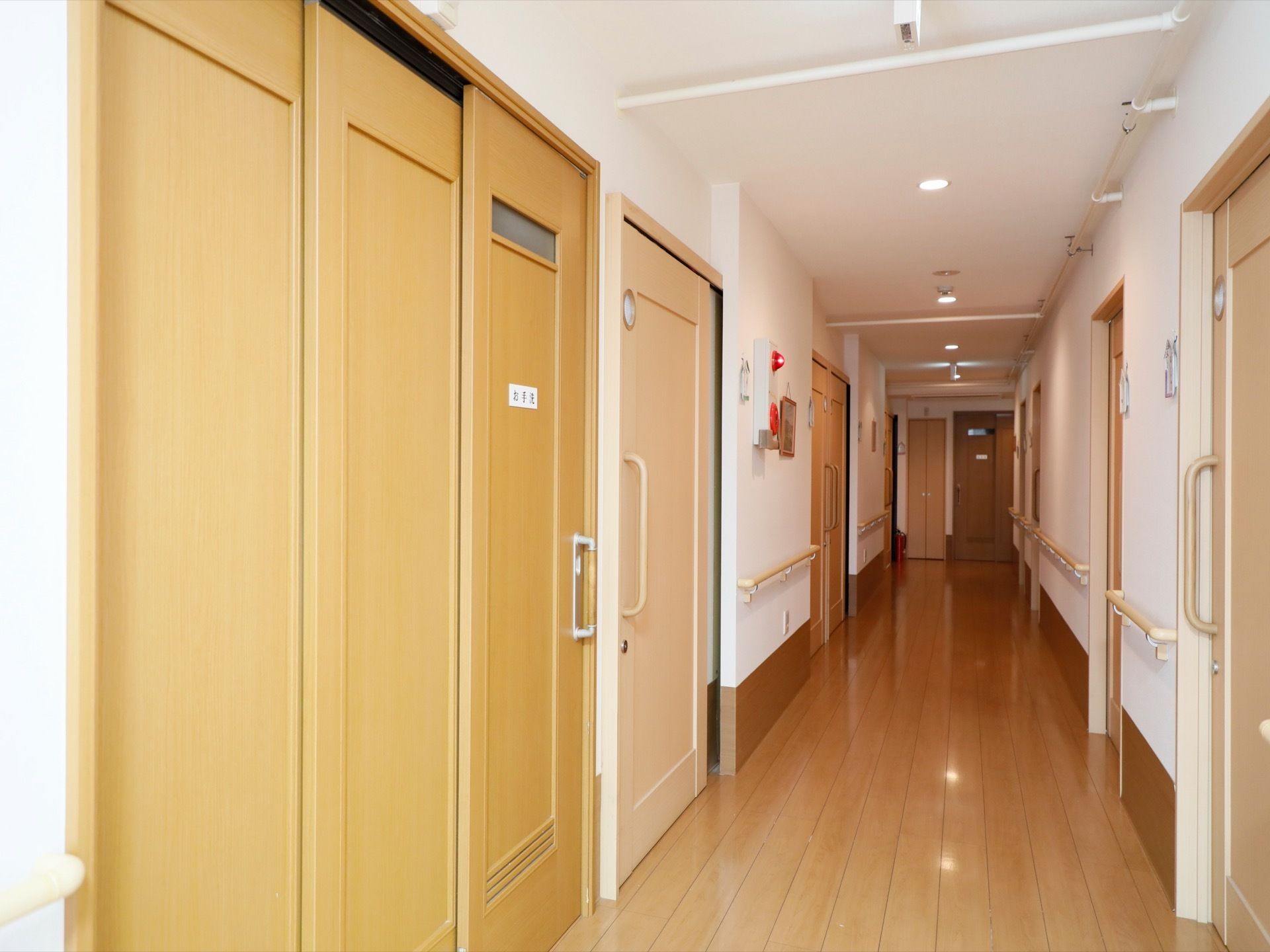 通路を挟むようにして、対面式に部屋が並んでいる。万一に備えて、非常ベルも設置されているので、すぐに職員が駆けつける事ができる。