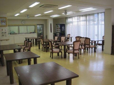 ひじ掛け付きの椅子といくつかのテーブルが置かれた広い部屋