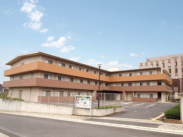 「みんなの家・土呂栄光荘」の外観。駐車場がある。