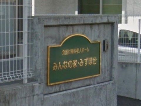 門には、本施設名が書かれた緑色のプレートをはめ込まれている。プレート近くには呼び出しボタンを取り付けている。