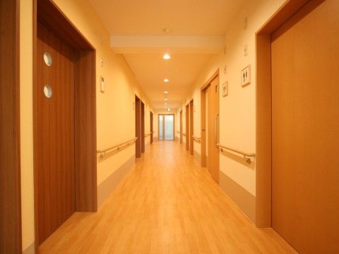 バリアフリー構造の廊下の両脇には、手すりを取り付けているので移動がしやすい。各居室は外から中が見えないようになっている。