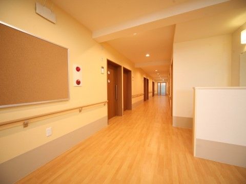 廊下の内装は温かみがある色を採用し、車椅子をご利用の方も移動しやすい広さを確保している。非常時の消防設備も取り付けている。