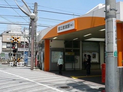 オレンジと白に塗られた駅。駅の中には、近隣の地図と対面式の切符売り場がある。本施設へは公共交通機関でアクセスできる。