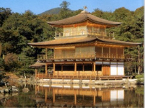 陽を受けて輝き、豊かな緑の中、池に姿を映す金色の古い寺