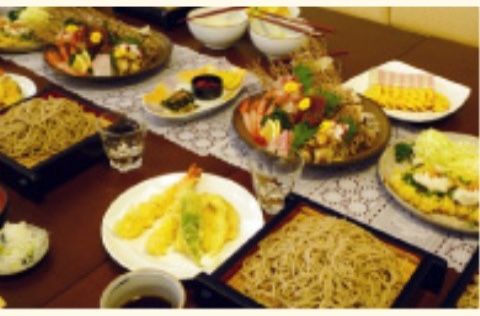 刺身の盛り合わせと天ぷら、ざるそばが並ぶ、豪華に見える食卓